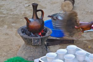 a jebena clay pot brewing coffee on a charcoal cooker
